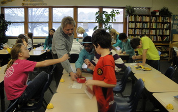 teacher and students in a classroom working to germinate seeds